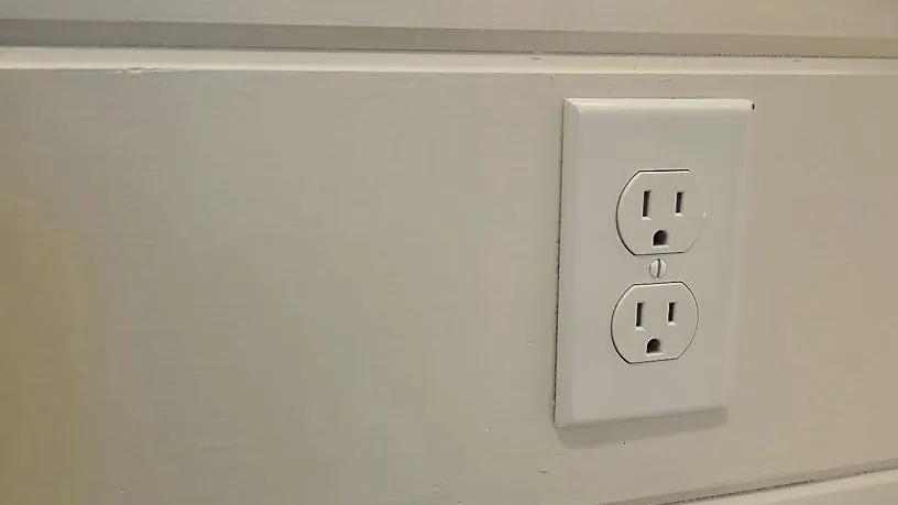 Receptacle installed on a shiplap wall beside a countertop