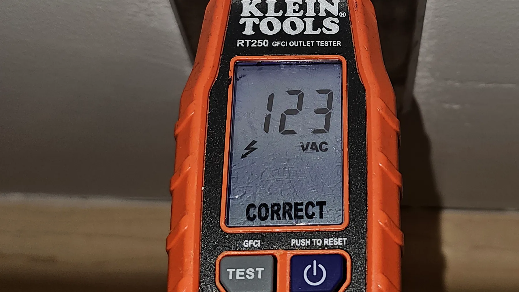 Digital receptacle tester confirming correct wiring on an outlet